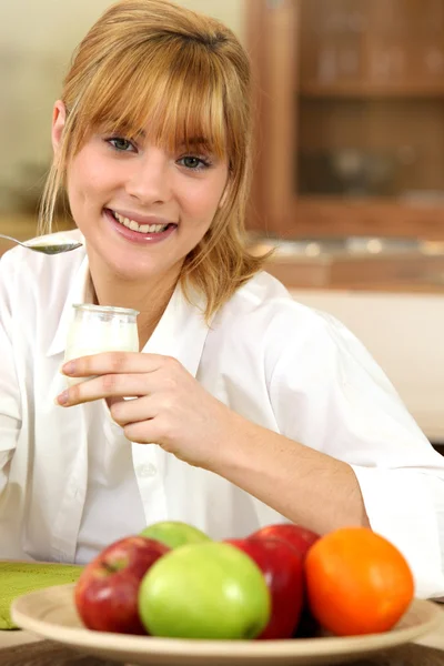 Mujer joven comiendo una olla de yogur — Foto de Stock