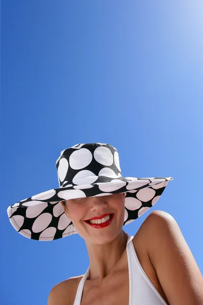Brunette stood on a beach wearing swim wear and spotted hat — Stok fotoğraf