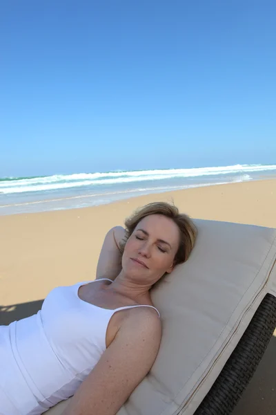 Mulher relaxante em uma cadeira de praia — Fotografia de Stock