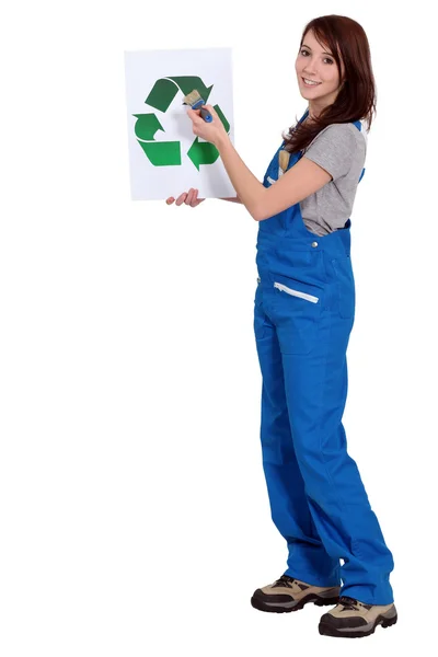 Uma trabalhadora manual segurando um sinal de reciclagem . — Fotografia de Stock