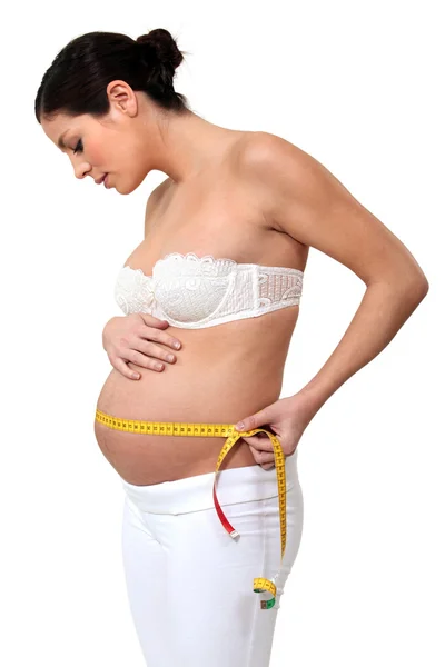 Беременная женщина, измеряющая живот — стоковое фото
