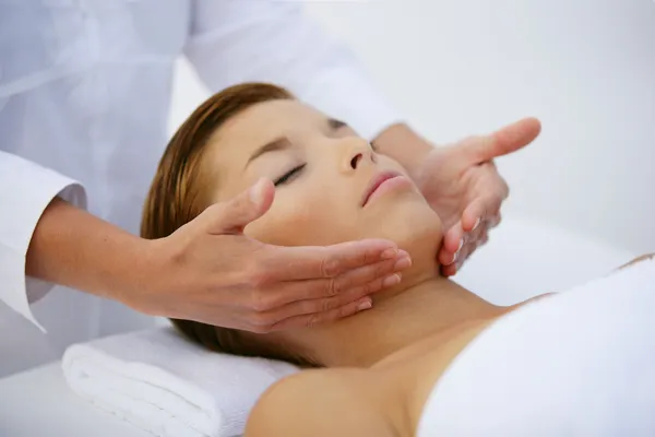 Молода жінка розслабляється під час масажу обличчя — стокове фото