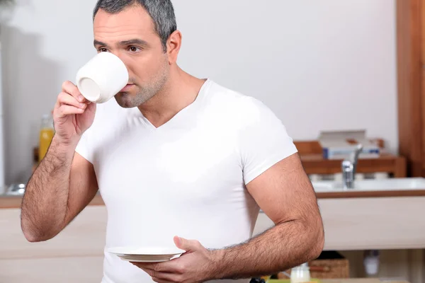 Uomo che beve caffè in cucina — Foto Stock