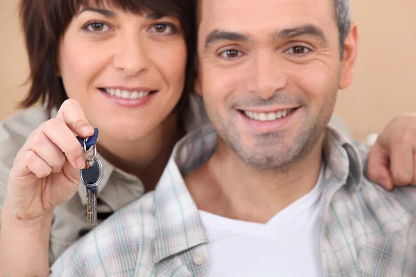 Mature couple holding up a set of keys — Stock Photo, Image