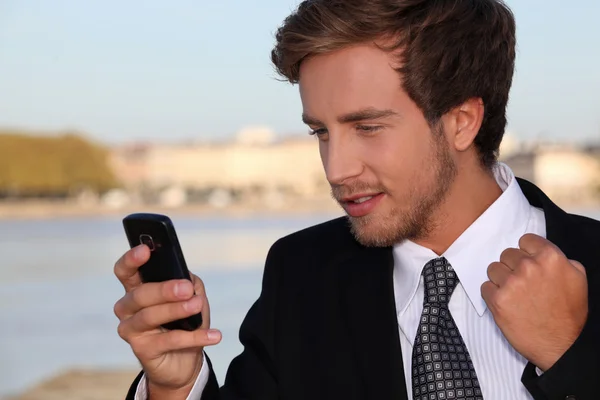Young executive pleased with his phone message — Stock Photo, Image