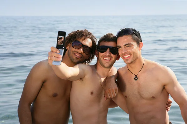 Трое мужчин на пляже — стоковое фото