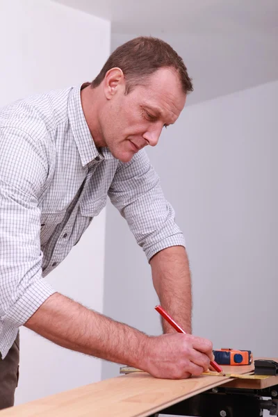 Homme marquant un plancher avec un crayon — Photo