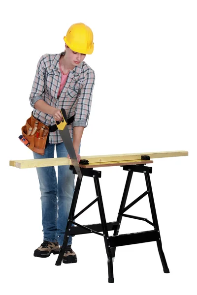 Handywoman snijden een plank — Stockfoto