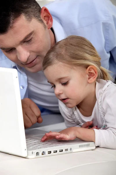 父亲和女儿使用一台便携式计算机 — 图库照片