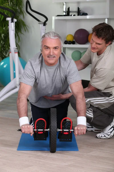 Homem de meia-idade trabalhando com personal trainer — Fotografia de Stock