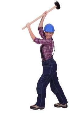 Woman raising sledge-hammer in the air clipart