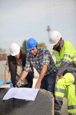 Construction workers looking at site plans clipart