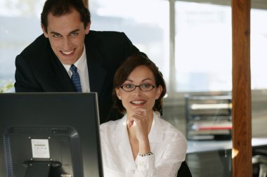 Co-workers in front of desktop computer clipart