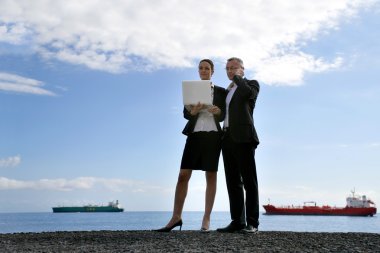 Business couple in front of tankers clipart