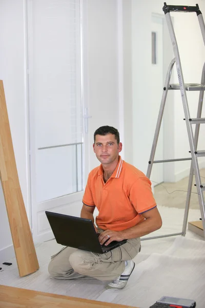 Floorlayer com um computador portátil — Fotografia de Stock