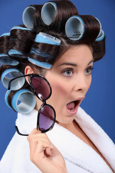 Una bruna stordita con i rulli per capelli . — Foto Stock