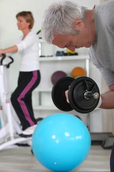 Older couple working out in gym — Stock Photo, Image