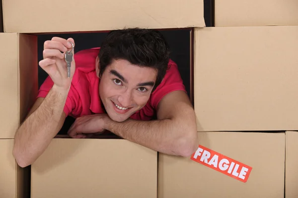 열쇠를 들고 있는 제거 상자 속에 있는 젊은 남자의 모습 — 스톡 사진