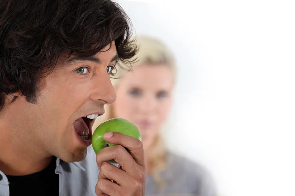 Человек ест яблоко — стоковое фото