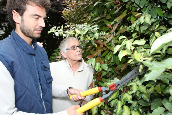 Giovane uomo giardinaggio con donna più anziana — Foto Stock