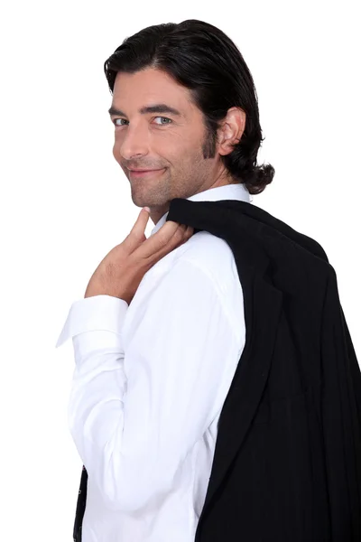 Roguish caballero sosteniendo su chaqueta sobre su hombro — Foto de Stock