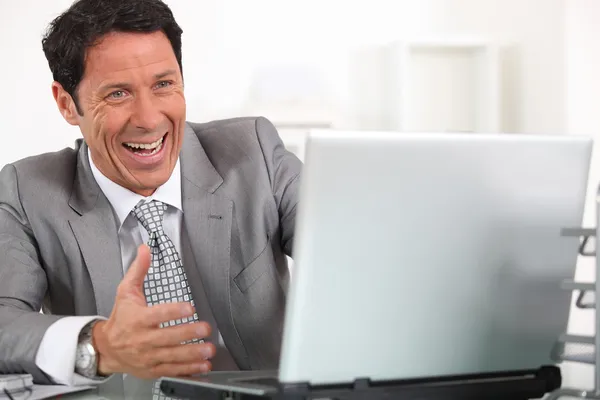 Muž hystericky smát na svém přenosném počítači — Stock fotografie