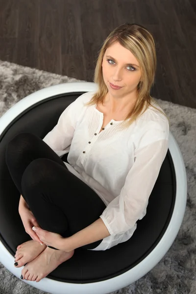 Блондинка, сидящая в чаше в положении колена и груди — стоковое фото