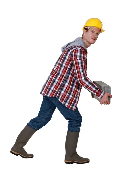 Hombre llevando ladrillo pesado — Foto de Stock