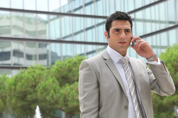 Businessman outdoors talking on phone — Stock Photo, Image