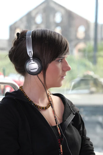 stock image A young woman with headphones on her head.