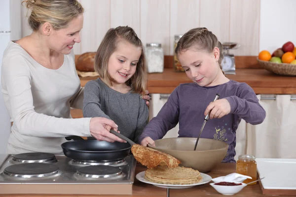 Mother and daughters making pancakes — Stock Photo, Image