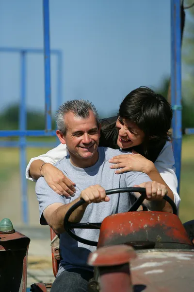 Couple riding tractor — Stock Photo, Image