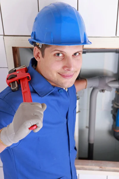Loodgieter buizen installeren met een grote moersleutel — Stockfoto