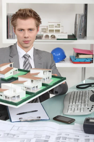 Arkitekt som håller upp en byggnad modell — Stockfoto