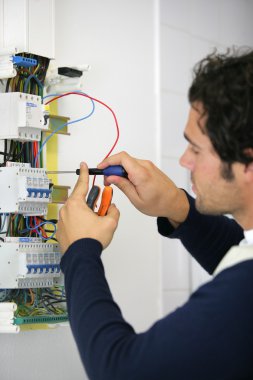 Man repairing faulty fuse box clipart