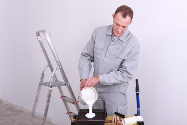 Decorator pouring paint into a tray clipart