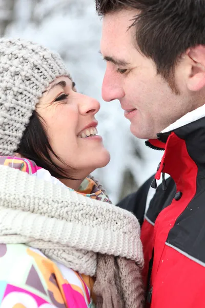 Casal feliz beijando na neve — Fotografia de Stock