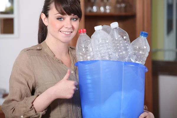 Женщина перерабатывает пластиковые бутылки — стоковое фото