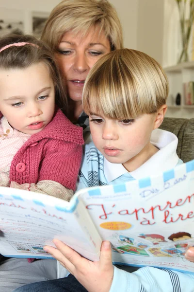 Moeder lezen met haar twee kinderen boek — Stockfoto
