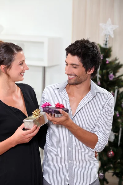 Paar tauscht Weihnachtsgeschenke aus — Stockfoto