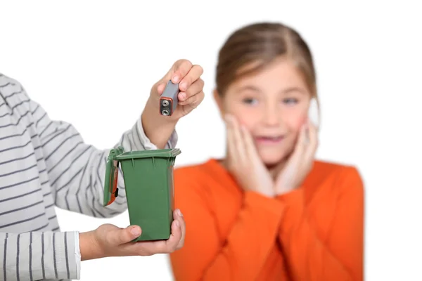 Mädchen entsetzt darüber, dass jemand eine Batterie in den Mülleimer legt — Stockfoto