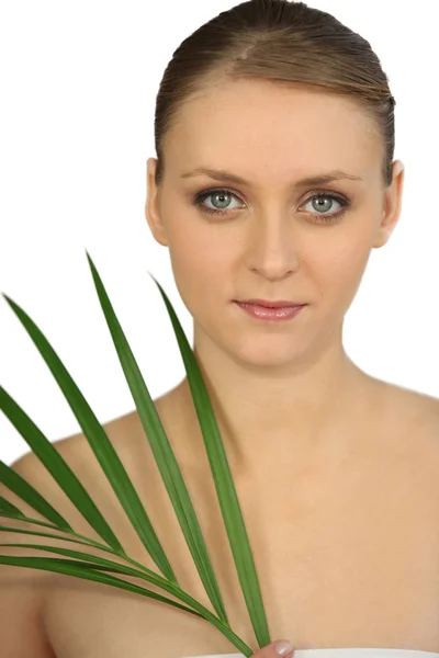 Brustschuss der anmutigen Blondine mit den blauen Augen und der Pflanze — Stockfoto