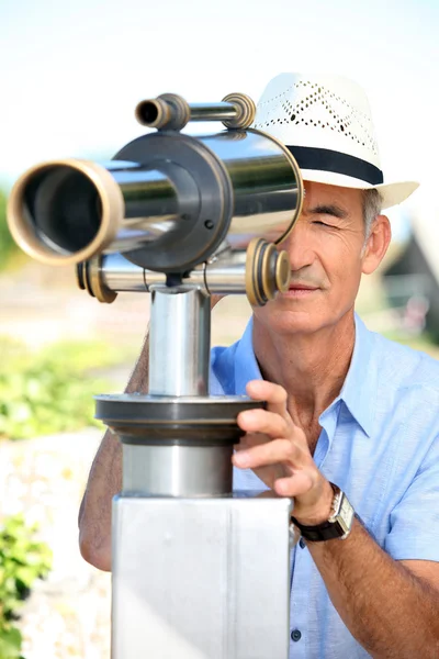Людина дивиться через телескоп — стокове фото