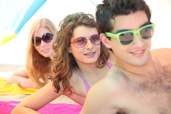 Trzech młodych mężczyzn, nosi okulary przeciwsłoneczne na plaży — Zdjęcie stockowe