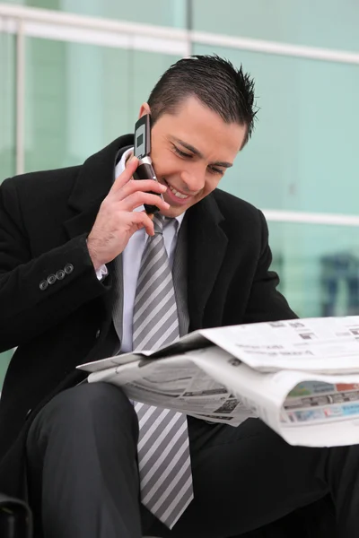 Businessman sat with newspaper — Stock Photo, Image