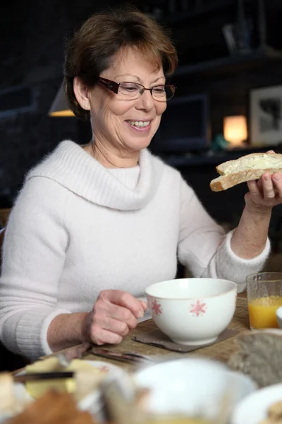 Mulher madura tendo um café da manhã de inverno — Fotografia de Stock