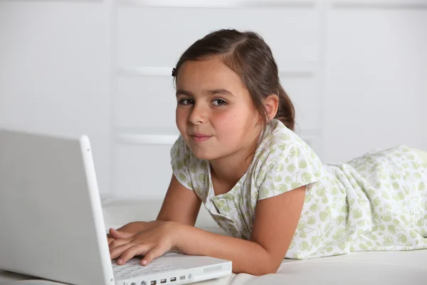 Mädchen liegt mit Computer — Stockfoto