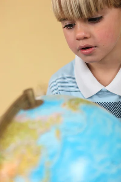 Petit garçon qui regarde le globe — Photo