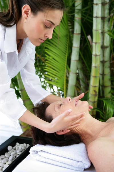 Mulher madura fazendo massagem facial — Fotografia de Stock