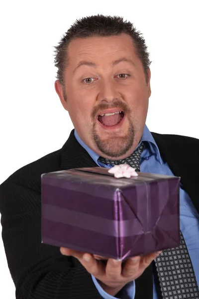 Businessman openmouthed at a gift — Stock Photo, Image